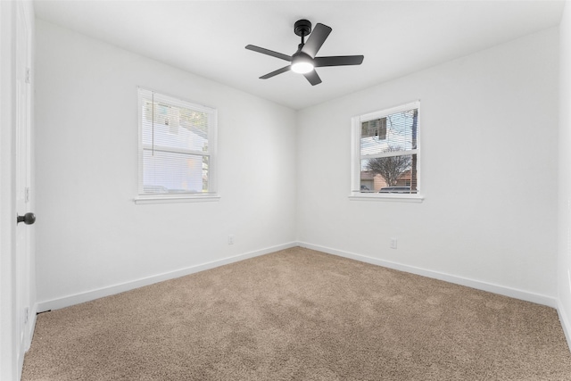 carpeted empty room with a healthy amount of sunlight, baseboards, and ceiling fan