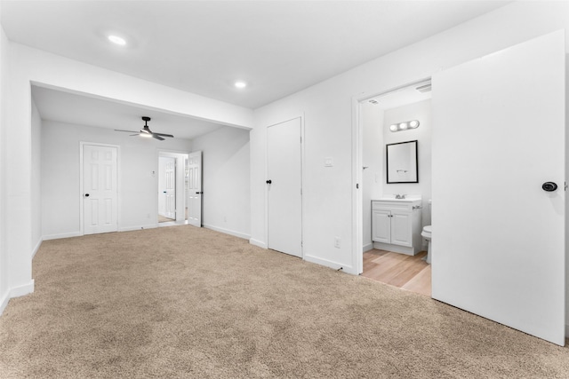 unfurnished bedroom with recessed lighting, baseboards, light carpet, and ensuite bath