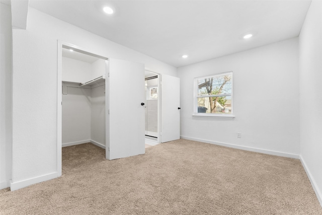 unfurnished bedroom featuring recessed lighting, a closet, carpet floors, baseboards, and a spacious closet