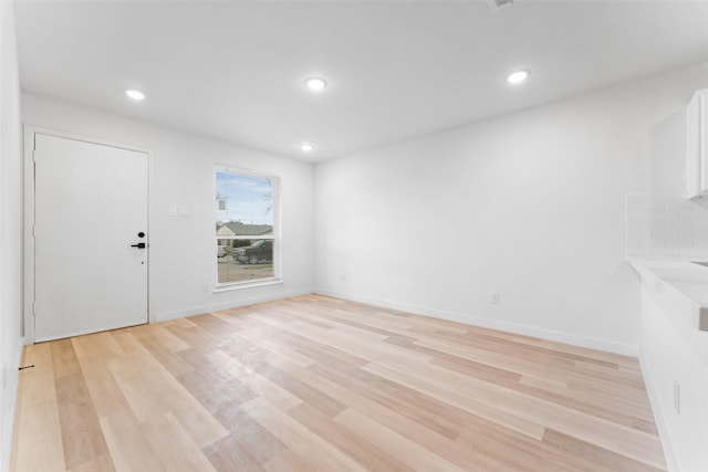 unfurnished room featuring recessed lighting, baseboards, and light wood-style flooring