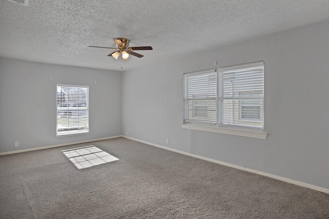 spare room with ceiling fan, a textured ceiling, baseboards, and carpet