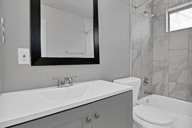 full bathroom featuring toilet,  shower combination, vanity, and a textured wall