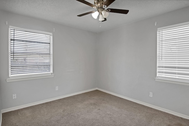 empty room featuring a ceiling fan, baseboards, a textured ceiling, and carpet flooring