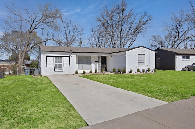 view of front of home with a front yard, cooling unit, fence, and brick siding