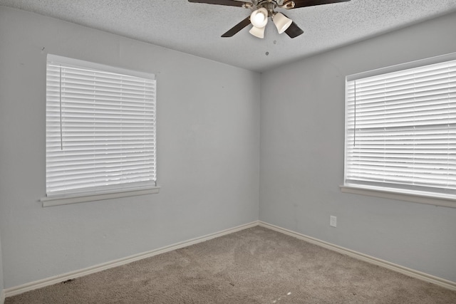 spare room with baseboards, carpet, a ceiling fan, and a textured ceiling