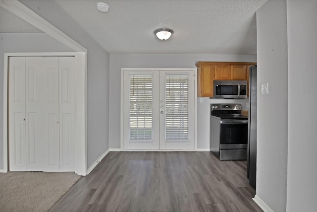 kitchen with dark wood finished floors, french doors, stainless steel appliances, and a textured ceiling