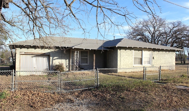 view of front facade featuring a fenced front yard, a gate, and an attached garage