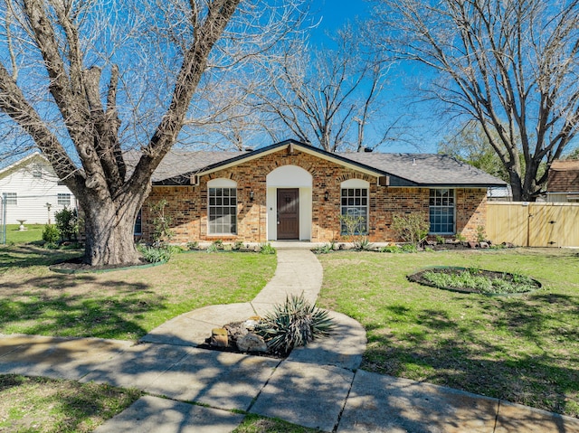 view of front of house with a front lawn, a gate, fence, and brick siding