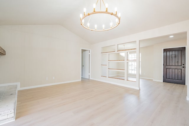 interior space featuring an inviting chandelier, vaulted ceiling, built in shelves, and light wood finished floors