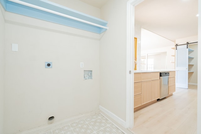 clothes washing area featuring a barn door, baseboards, hookup for an electric dryer, and hookup for a washing machine