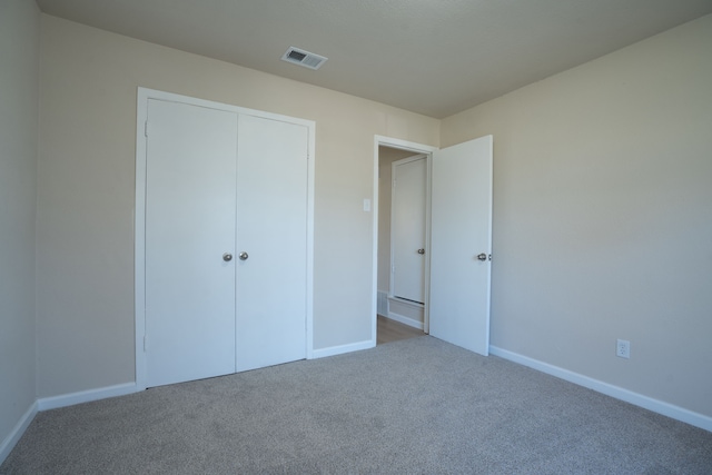 unfurnished bedroom with carpet, visible vents, a closet, and baseboards