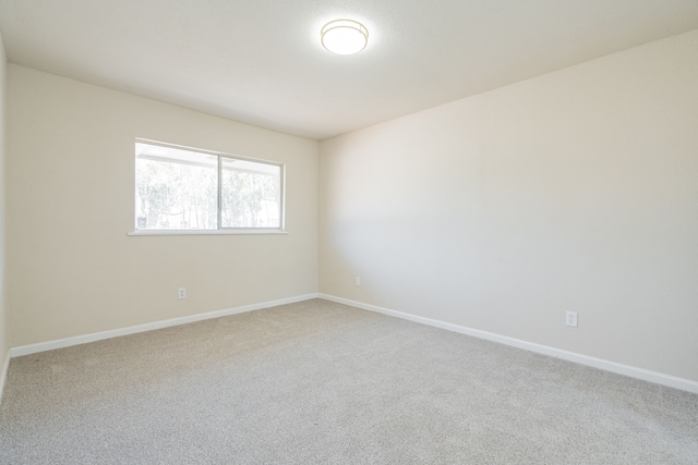 spare room with carpet flooring and baseboards