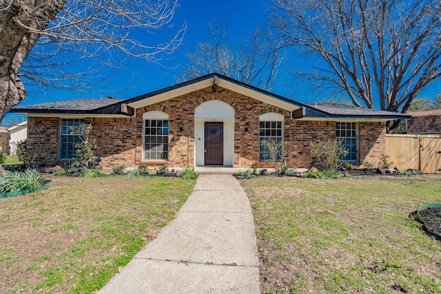 ranch-style house with brick siding, a front yard, and fence