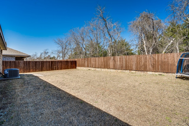 view of yard with central AC unit and a fenced backyard