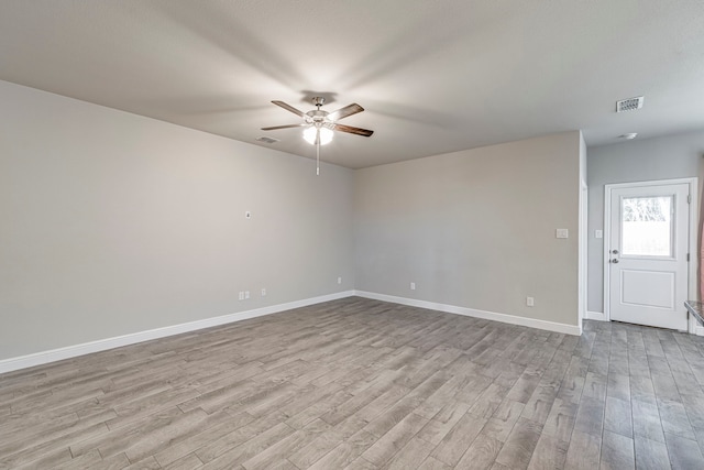 unfurnished room with visible vents, ceiling fan, baseboards, and wood finished floors