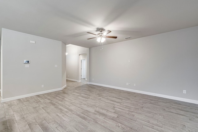 unfurnished room featuring baseboards, visible vents, a ceiling fan, and light wood-style floors