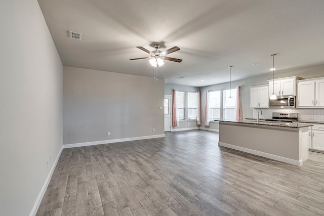 kitchen with light wood finished floors, visible vents, appliances with stainless steel finishes, and open floor plan