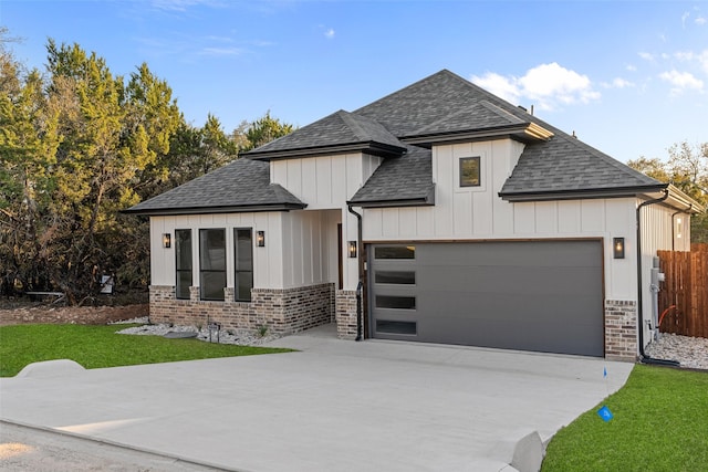 modern farmhouse featuring a front lawn, board and batten siding, concrete driveway, an attached garage, and a shingled roof