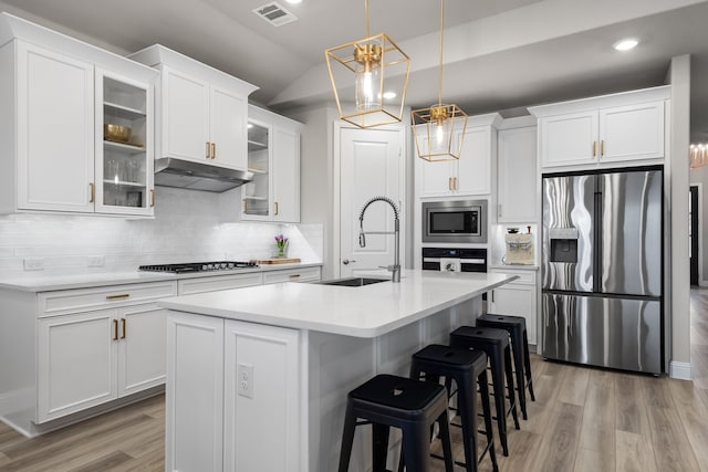 kitchen with visible vents, light countertops, appliances with stainless steel finishes, light wood-style floors, and a sink