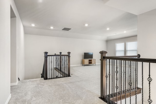 hallway featuring recessed lighting, visible vents, an upstairs landing, and carpet floors