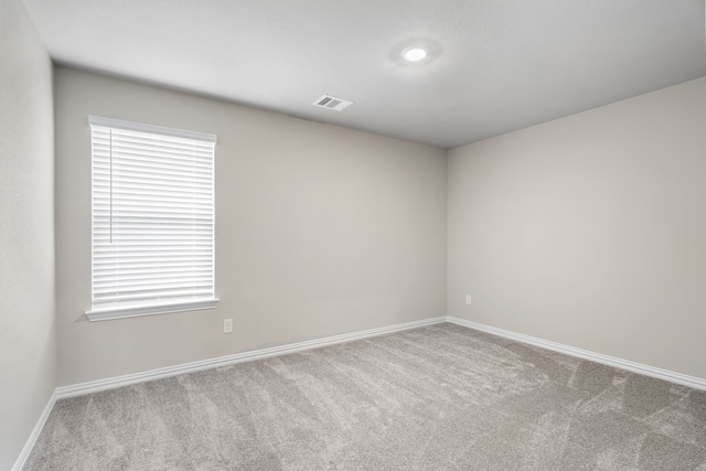 empty room featuring baseboards, visible vents, and carpet floors