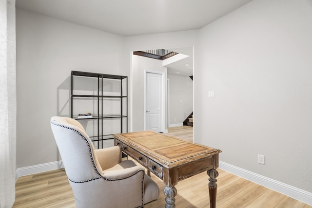 home office featuring baseboards and light wood finished floors