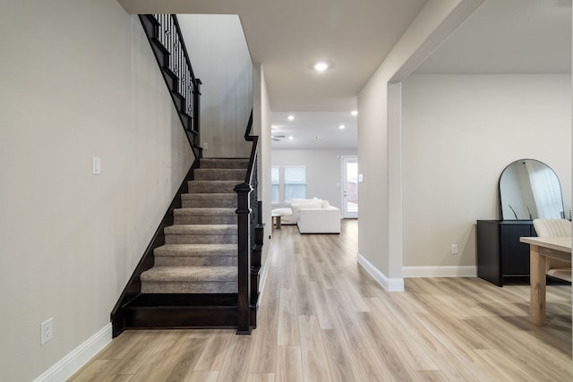 stairway featuring recessed lighting, baseboards, and wood finished floors