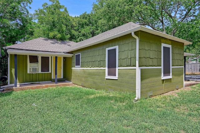 single story home featuring board and batten siding, fence, a front yard, and roof with shingles