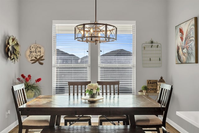 dining space featuring a healthy amount of sunlight, baseboards, and a chandelier