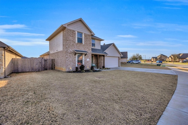 traditional-style house with concrete driveway, an attached garage, fence, and brick siding