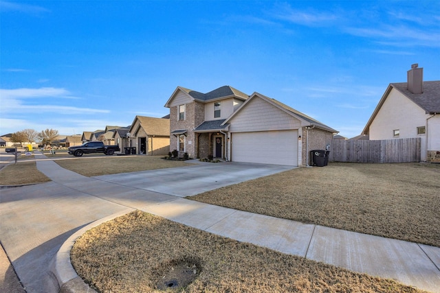 view of front of house with brick siding, a front lawn, fence, concrete driveway, and a garage