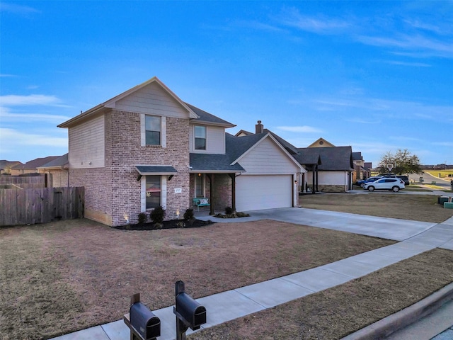 traditional home featuring a front yard, fence, driveway, an attached garage, and brick siding