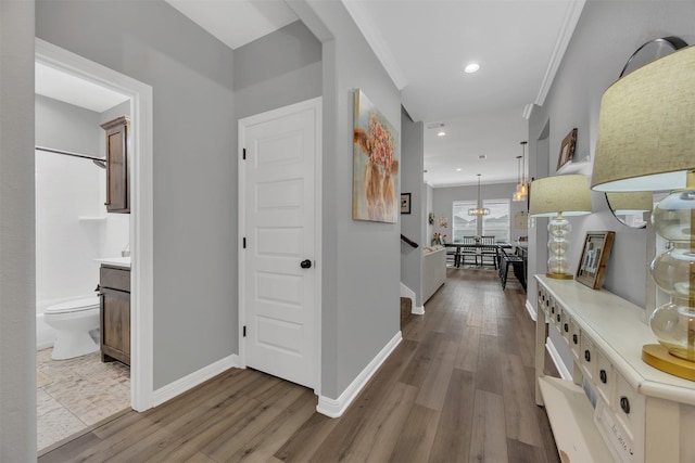 hall featuring recessed lighting, ornamental molding, baseboards, and wood finished floors