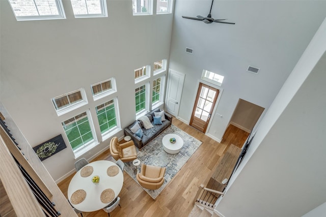 living area with visible vents, baseboards, and wood finished floors