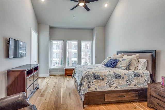 bedroom with a ceiling fan, light wood-style floors, and baseboards