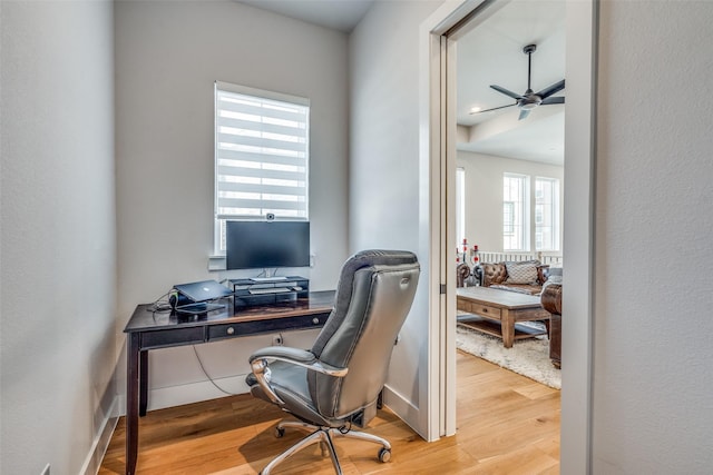 office space featuring baseboards, a ceiling fan, and wood finished floors