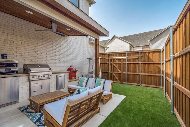 view of yard featuring an outdoor hangout area, a patio, an outdoor kitchen, and fence