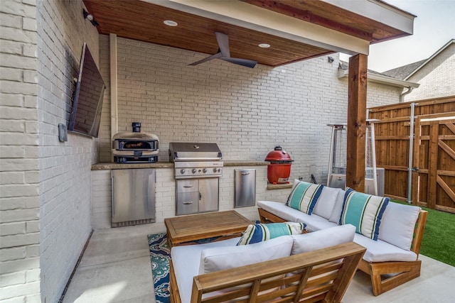 view of patio with a ceiling fan, fence, an outdoor kitchen, grilling area, and outdoor lounge area