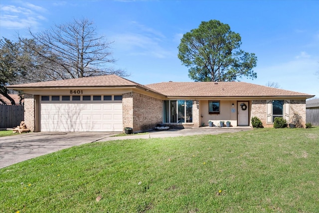 ranch-style home with fence, concrete driveway, a front yard, a garage, and brick siding