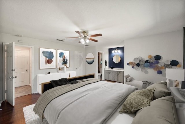 bedroom featuring dark wood finished floors, a ceiling fan, visible vents, and connected bathroom