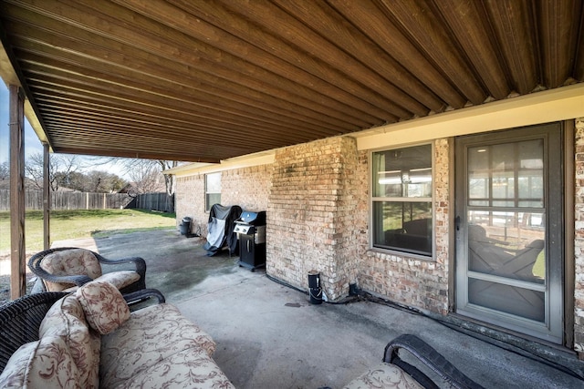 view of patio with area for grilling and fence