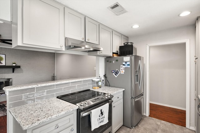 kitchen featuring under cabinet range hood, visible vents, light stone counters, and appliances with stainless steel finishes