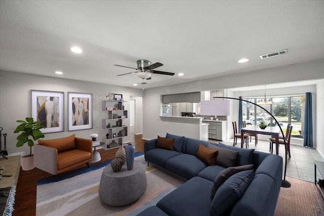 living area featuring recessed lighting, visible vents, wood finished floors, and ceiling fan with notable chandelier