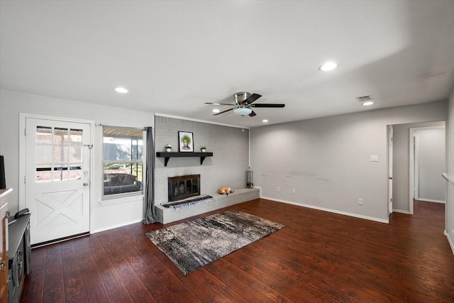 living room featuring visible vents, baseboards, recessed lighting, a fireplace, and wood-type flooring