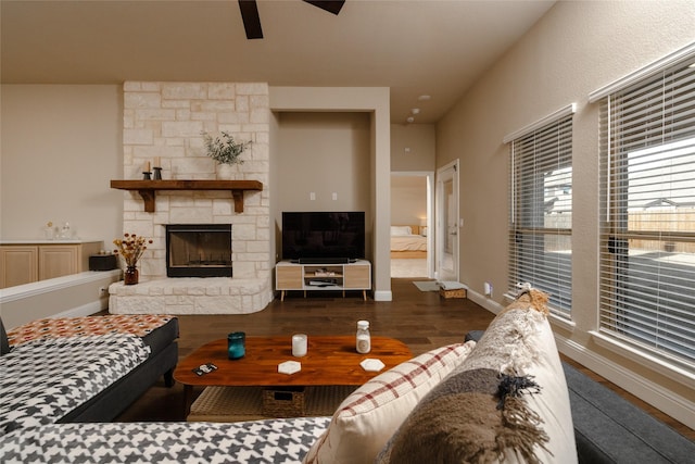 living area with ceiling fan, baseboards, wood finished floors, and a fireplace