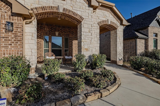 entrance to property with stone siding and brick siding