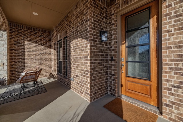 entrance to property featuring brick siding