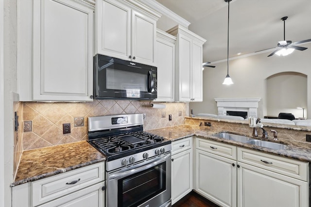 kitchen featuring a ceiling fan, stainless steel range with gas stovetop, a sink, decorative backsplash, and black microwave