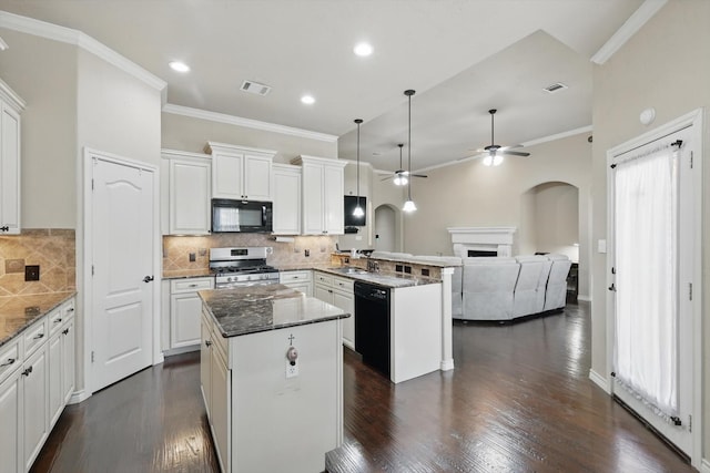 kitchen with black appliances, a peninsula, arched walkways, and a kitchen island