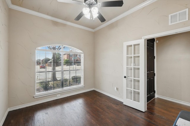 spare room featuring visible vents, baseboards, wood finished floors, and crown molding